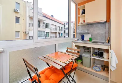 a balcony with a table and chairs and a kitchen at Студио Патрисия in Pomorie