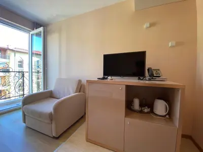 a room with a chair and a tv and a phone at MESSEMBRIA B504 Studio Sunny Beach in Sunny Beach