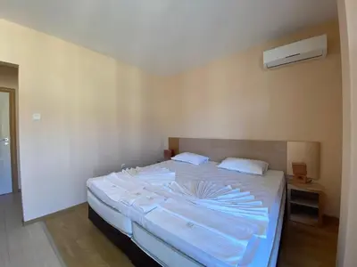a bedroom with a large bed with white sheets at MESSEMBRIA B504 Studio Sunny Beach in Sunny Beach