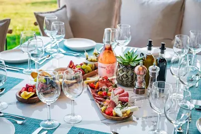 a table with wine glasses and a plate of food at Voya Beach Resort - Ultra All Inclusive in Sveti Vlas