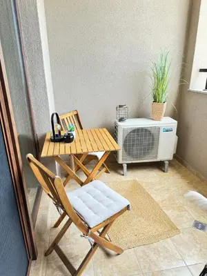 a small balcony with a table and chairs and a heater at City view in Residences in Burgas City