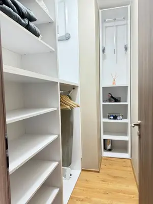 a walk in closet with white shelves and a wooden floor at City view in Residences in Burgas City