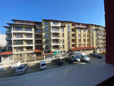 a group of cars parked in a parking lot in front of a building at MESSEMBRIA A309 Studio Sunny Beach in Sunny Beach