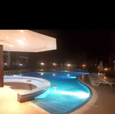 a large swimming pool at night with lights at Victoria's apartments Nesebar in Nesebar