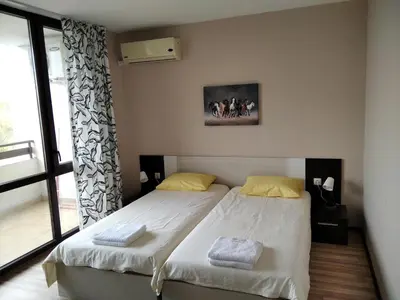 a bedroom with two twin beds and a window at Victoria's apartments Nesebar in Nesebar