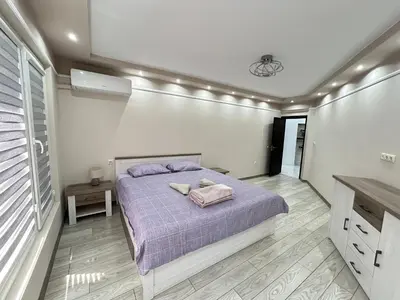 a bedroom with a purple bed in a room with a window at Apartament deluxe Karina-Free parking in Burgas City