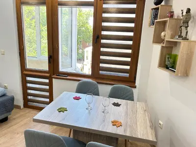 a dining room with a table with wine glasses on it at Apartament deluxe Karina-Free parking in Burgas City