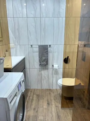 a bathroom with a washing machine and a toilet at Apartament deluxe Karina-Free parking in Burgas City