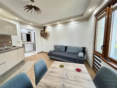 a living room with a table and a couch at Apartament deluxe Karina-Free parking in Burgas City