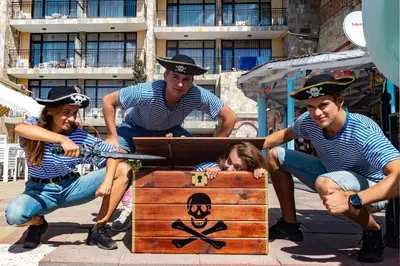 a group of people sitting around a treasure chest at Tiva del Mar Beach Hotel in Sveti Vlas