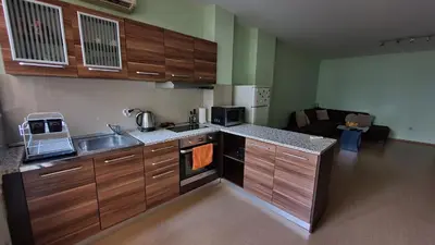 a kitchen with wooden cabinets and a sink in a room at Minimalistic 1BR flat with a Parking spot in Varna City
