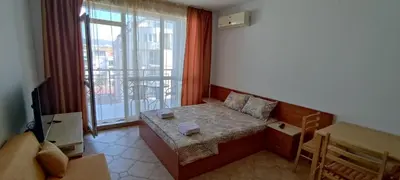 a room with a couch and a table and a window at Central Plaza - Studio - Sunny Beach in Sunny Beach