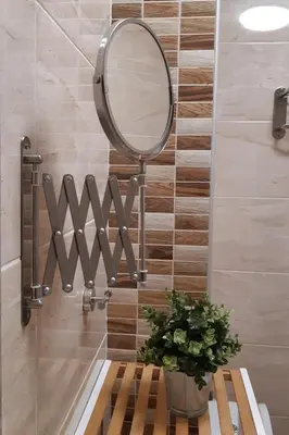 a bathroom with a mirror on a wall at Апартамент Адикт in Sozopol