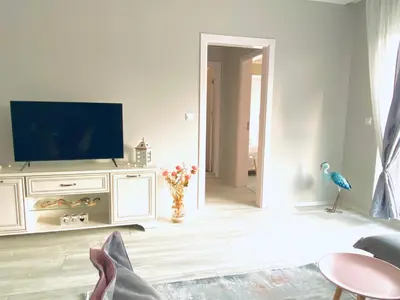 a living room with a television and a bird on a cabinet at Apartments in complex PANORAMA in Chernomorets