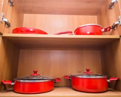 two pots and pans on shelves in a kitchen at Best Price - Downtown Flat in Burgas City