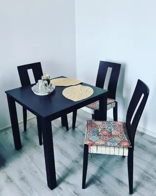 a black dining table and two chairs with a plate on it at Atlantis Resort Sea View in Burgas City