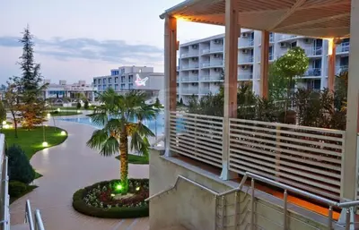 a resort with a palm tree and a building at Atlantis Resort Sea View in Burgas City