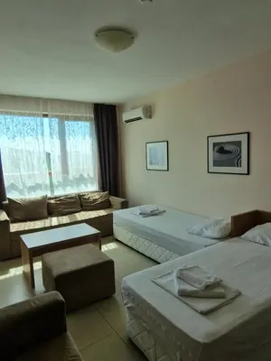 a hotel room with two beds and a couch at Александра in Sveti Vlas