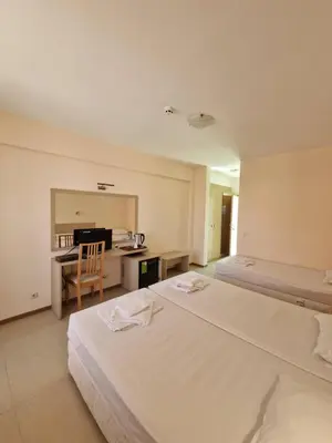a hotel room with two beds and a desk at Александра in Sveti Vlas
