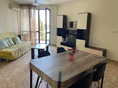 a living room with a table and chairs and a couch at private apartments in Apolon in Ravda