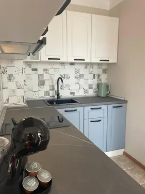 a kitchen with white cabinets and a counter top at Marea Garden apartments in Ravda