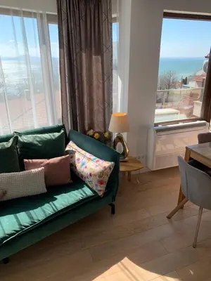 a living room with a green couch and large windows at CASA VISTA in Burgas City