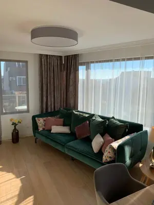 a living room with a green couch with pillows at CASA VISTA in Burgas City