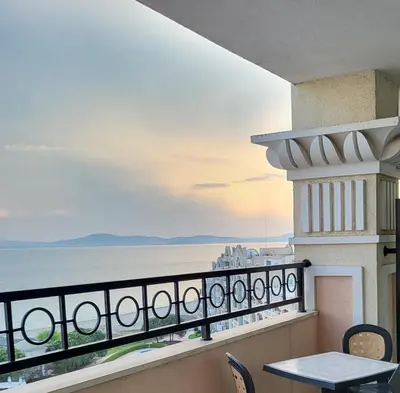 a balcony with a table and chairs and the ocean at 