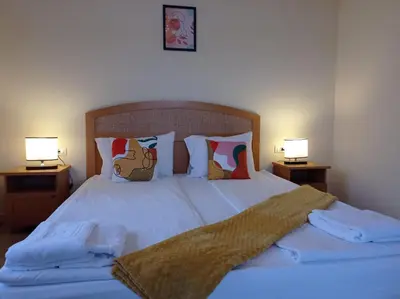 a bedroom with a bed with two lamps on both sides at Lilia Sun Apartment in Sozopol