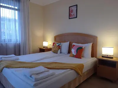 a bedroom with a large bed with two lamps at Lilia Sun Apartment in Sozopol