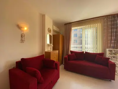 a living room with two red couches and a window at BLUE MARINE C16 Apartment Sunny Beach in Sunny Beach