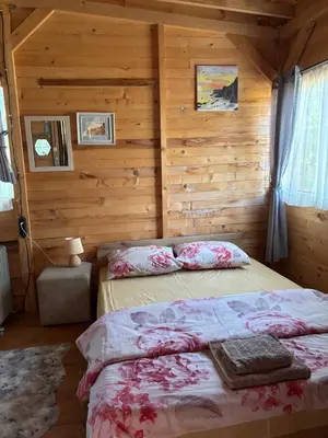 a bedroom with two beds in a log cabin at Вила Елия - почивка край морето in Lozenets