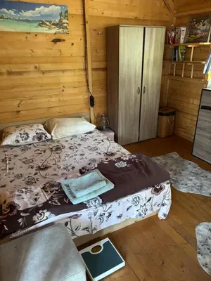 a bedroom with a bed in a wooden cabin at Вила Елия - почивка край морето in Lozenets