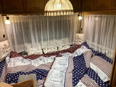 a bed with red white and blue blankets and pillows at Вила Елия - почивка край морето in Lozenets