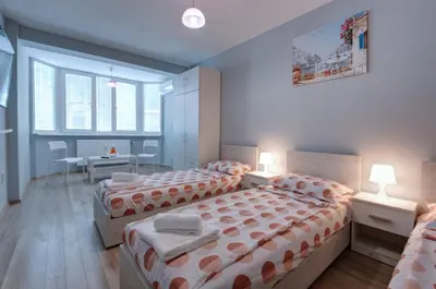 two beds in a room with two tables and two chairs at Daisy - 3 Room and kitchen apartment in Lazur in Burgas City
