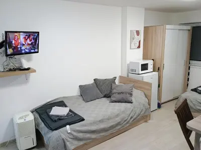 a bedroom with a bed and a tv on a wall at Болярска10 in Burgas City