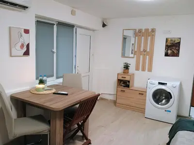 a living room with a table and a washing machine at Болярска10 in Burgas City