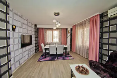 a dining room with a table and a tv at Perla 2-bdrm in the heart of the city in Varna City