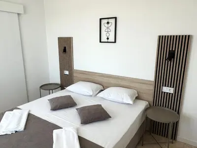 a bedroom with a white bed with two pillows at Villa Mia in Sozopol