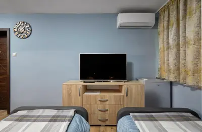 a room with two beds and a television on a cabinet at Top Center, Sea Garden, Brand New Studio - Majestic in Burgas City