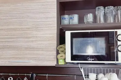 a microwave on a shelf in a kitchen at Уютен апартамент близо до морето IGROEG in Burgas City