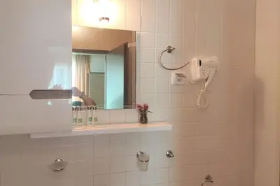 a bathroom with a mirror and a hair dryer at Уютен апартамент близо до морето IGROEG in Burgas City