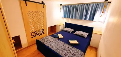a small room with a blue bed with pillows at Brand studio in Varna City