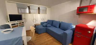 a living room with a blue couch and a tv at Brand studio in Varna City