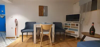 a living room with a table and chairs and a tv at Brand studio in Varna City