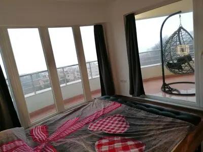 a bed with two pillows in a room with windows at Sun Gates Byala in Byala