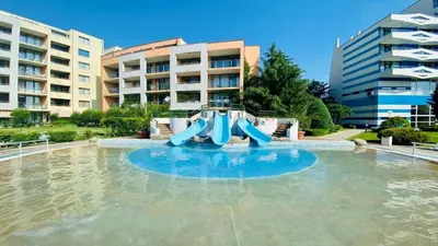 a water slide in a pool in front of a building at Trakia Plaza Apartment in Sunny Beach