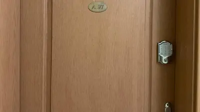 a wooden door with a clock on it at Trakia Plaza Apartment in Sunny Beach