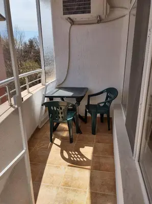 a balcony with two chairs and a table and a window at Dunav-Lazur Apt.5 in Ravda