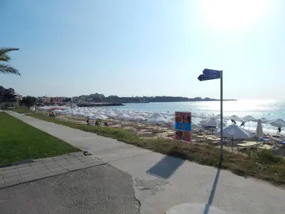 a street light next to a beach with umbrellas at Dunav-Lazur Apt.5 in Ravda